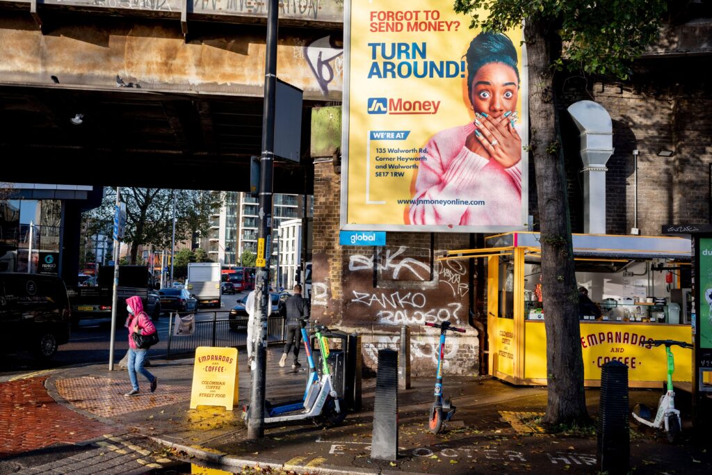 2TBRM4M A money transfer ad and a south American Empanada and coffee kiosk at Elephant &amp; Castle in Southwark, on 8th December 2023, in London, England.