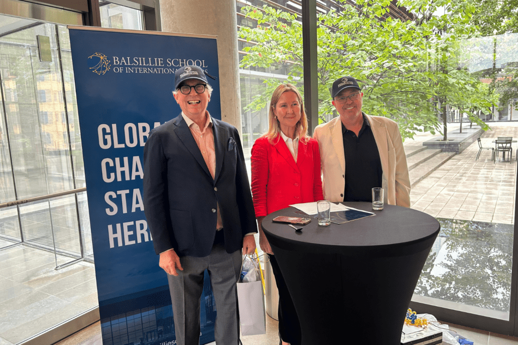Andy Cooper, Ann Fitz-Gerald and David Welch standing in front of the Balsillie School banner and courtyard