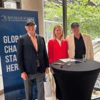 Andy Cooper, Ann Fitz-Gerald and David Welch standing in front of the Balsillie School banner and courtyard